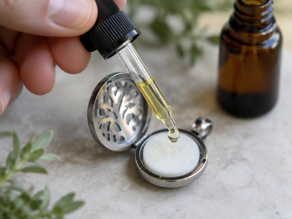 Gota de aceite esencial cayendo en la almohadilla de un medallón difusor